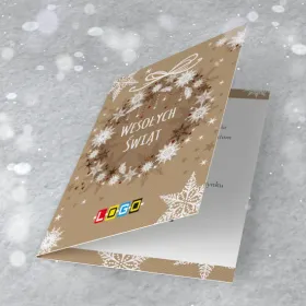 Wieniec ze śnieżynek i gałązek na brązowym tle z czerwonymi kropkami jak jagody, w środku napis życzeń