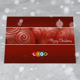 Bombki ze spiralami w poziomym pasie na czerwonym tle w prążki, po prawej biały napis „Merry Christmas”