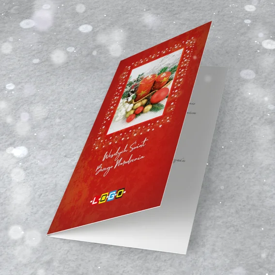 Wiklinowy koszyk z dwiema czerwonymi świecami, bombkami, świerkiem i szyszkami na zdjęciu w ramce z białych gwiazdek