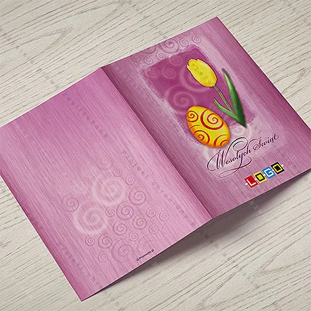 Żółte jajo w czerwone spirale i wysoki żółty tulipan na jasnoróżowej plamie akwareli, pod nimi fioletowy napis życzeń