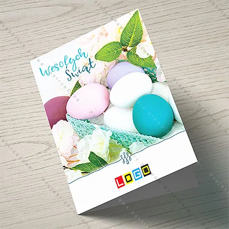Matowe jajka w kolorach burgundu, różu, lila i turkusu w koszyczku z włóczki wśród białych i różowych kwiatów