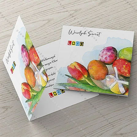 Akwarelowy czerwono-żółty tulipan nad stosem kolorowych pisanek w dolnym rogu, białe tło z błękitną plamą u góry