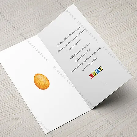 Biały środek karnetu z niewielkim jajkiem w pomarańczu po lewej i wolnym miejscem na życzenia oraz logo po prawej