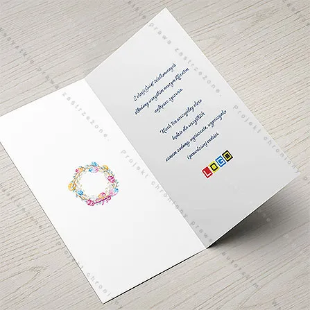 Białe wnętrze z miniaturą wianka po lewej i granatowym tekstem życzeń z drugim logo po prawej